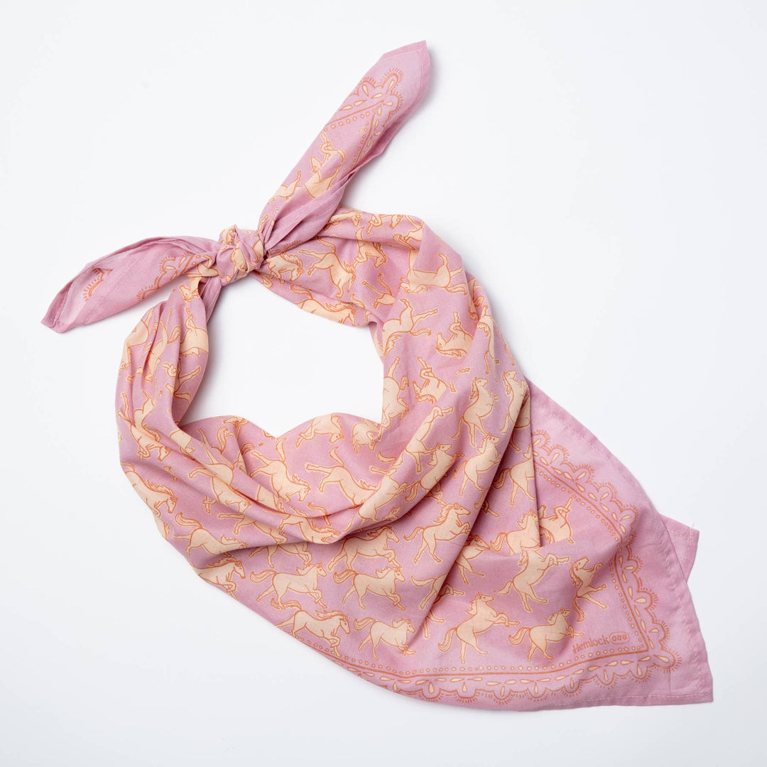 The Handker Bandanas 34" Wild Rag Horses Bandana, by Handker Bandanas, is a large pink cotton scarf with yellow horse motifs, shown tied loosely and displayed on a white background.