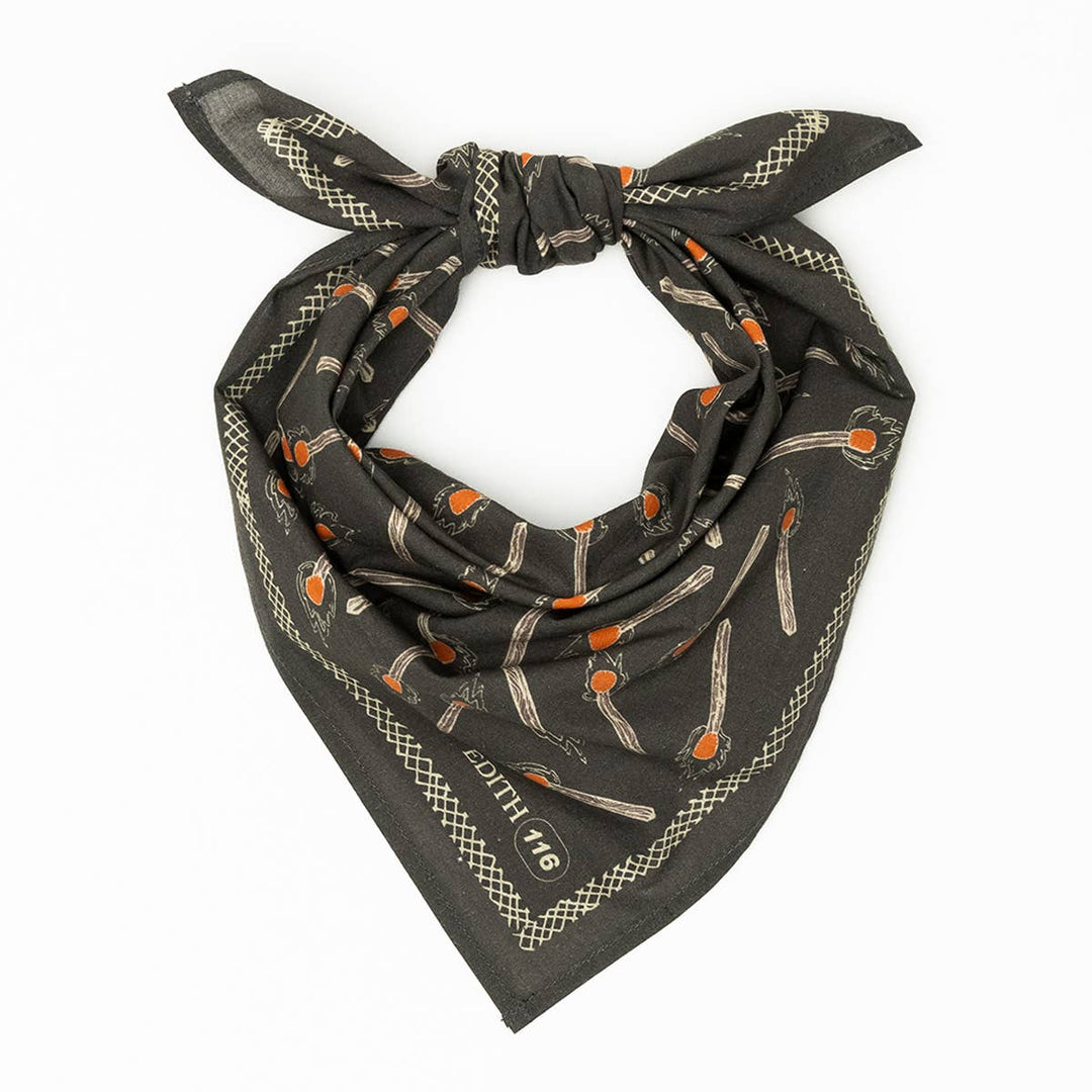 The Handker Bandanas - No. 116 Edith Bandana by Handker Bandanas is charcoal gray with a knotted top, orange and white matchstick print, a beige border, and "OUTH ’16" in one corner.
