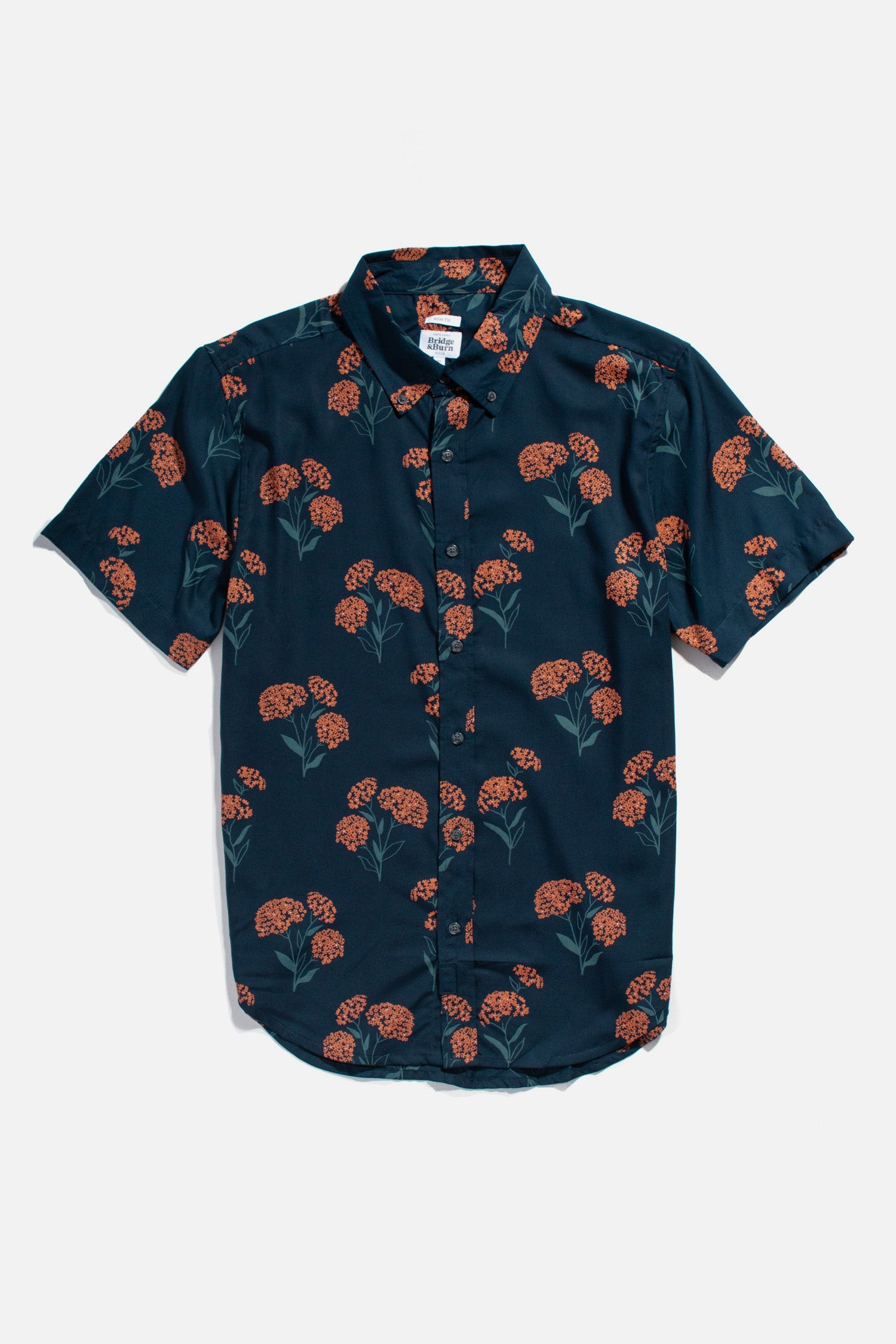 The Grant Slim Shirt / Wildflower by Bridge & Burn is a sustainable slim fit shirt with a dark blue base, orange floral pattern with green stems, short sleeves, collar, button-up front, and curved hem—ideal for summer style.