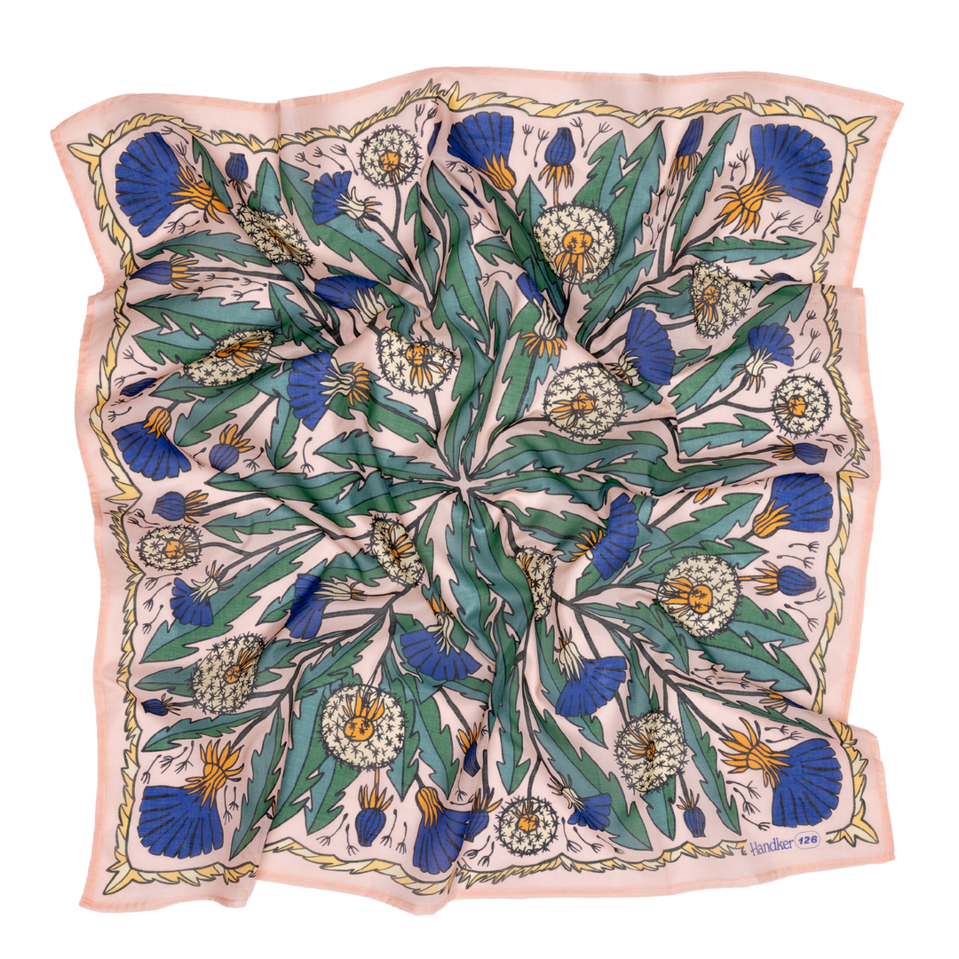 The Handker Bandanas 34" Dandy Wild Rag Bandana features an intricate floral pattern with green leaves, white dandelion-like flowers, and blue thistles on a pale background with a pink border, hand screen-printed for detail.