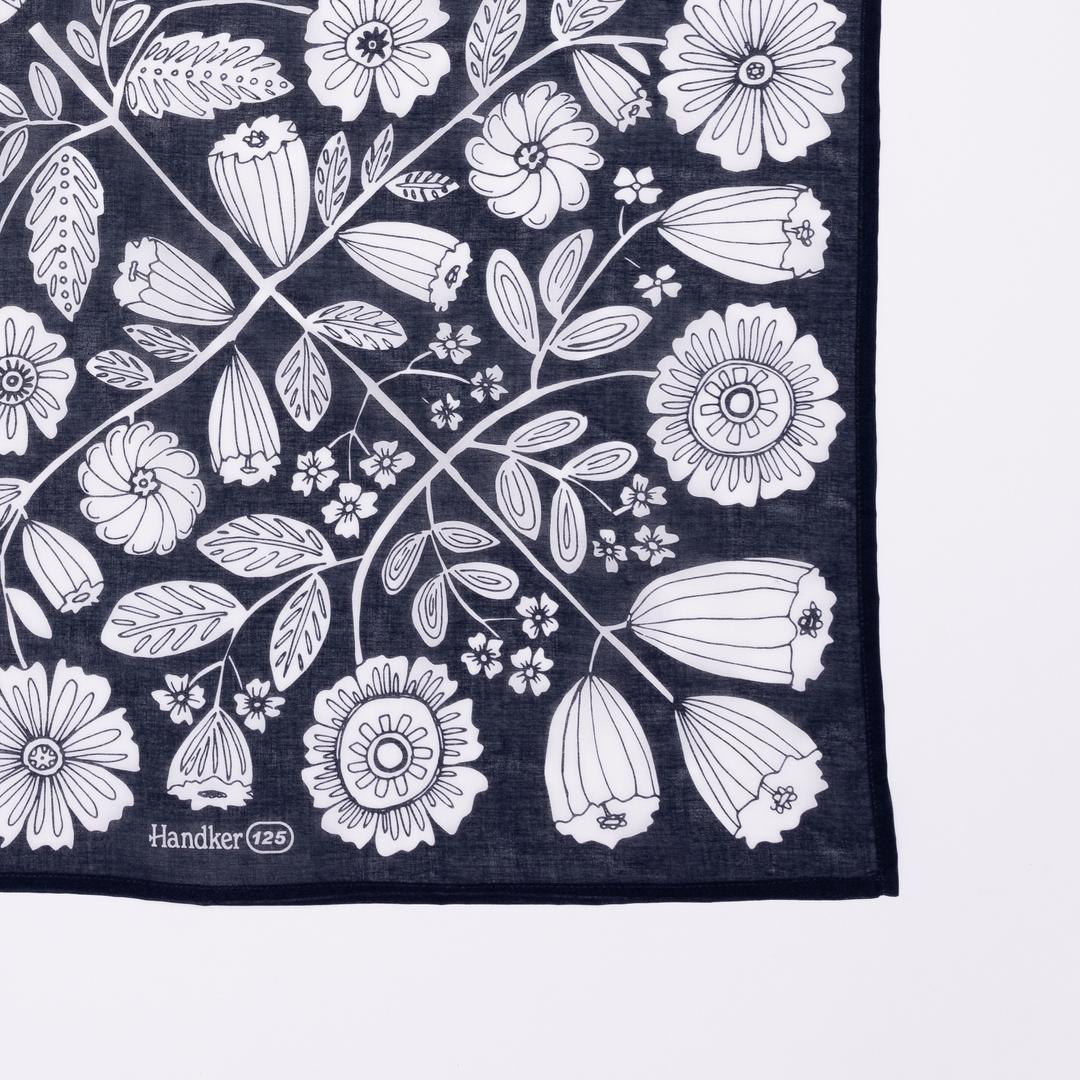 The Handker Bandanas 34" Wild Rag Fiona Bandana features navy blue cotton lawn with white floral and leaf botanical patterns, a hand screen-printed finish, and "Handker 125" labeled in the corner.