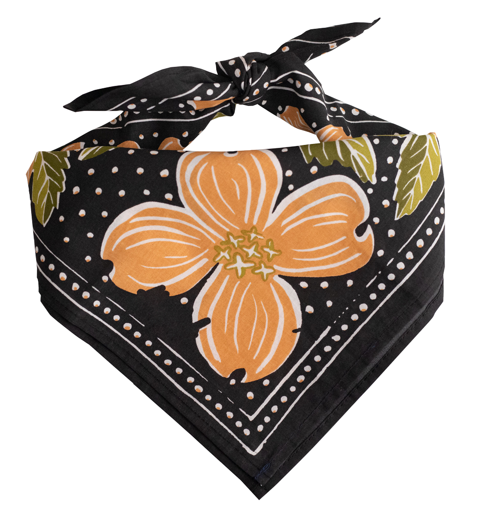 The Handker Bandanas - No. 046 Amy Bandana by Handker Bandanas features a large orange dogwood flower, green leaves, and white dotted patterns, folded and tied in a knot.