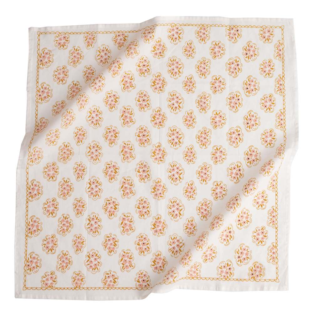 The Handker Bandanas - No. 042 Pearl Bandana by Handker Bandanas is a white cotton napkin featuring a repeating orange, yellow, and pink floral pattern with a decorative border. It is slightly wrinkled and laid flat.