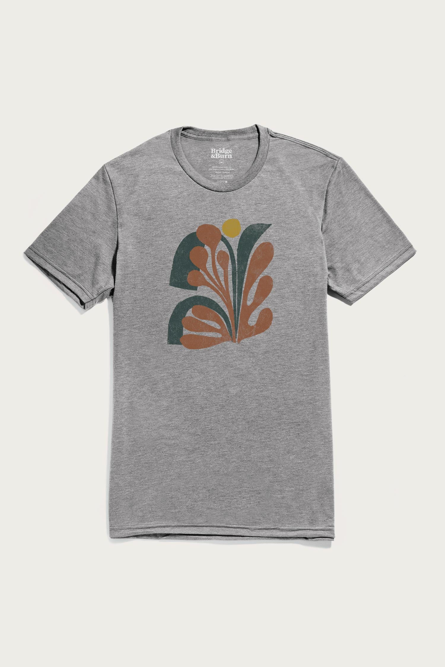 Bridge & Burn's Men's Bloom Tee in grey is a lightweight shirt featuring an abstract graphic with organic brown, dark green, and a small yellow circle on the chest.