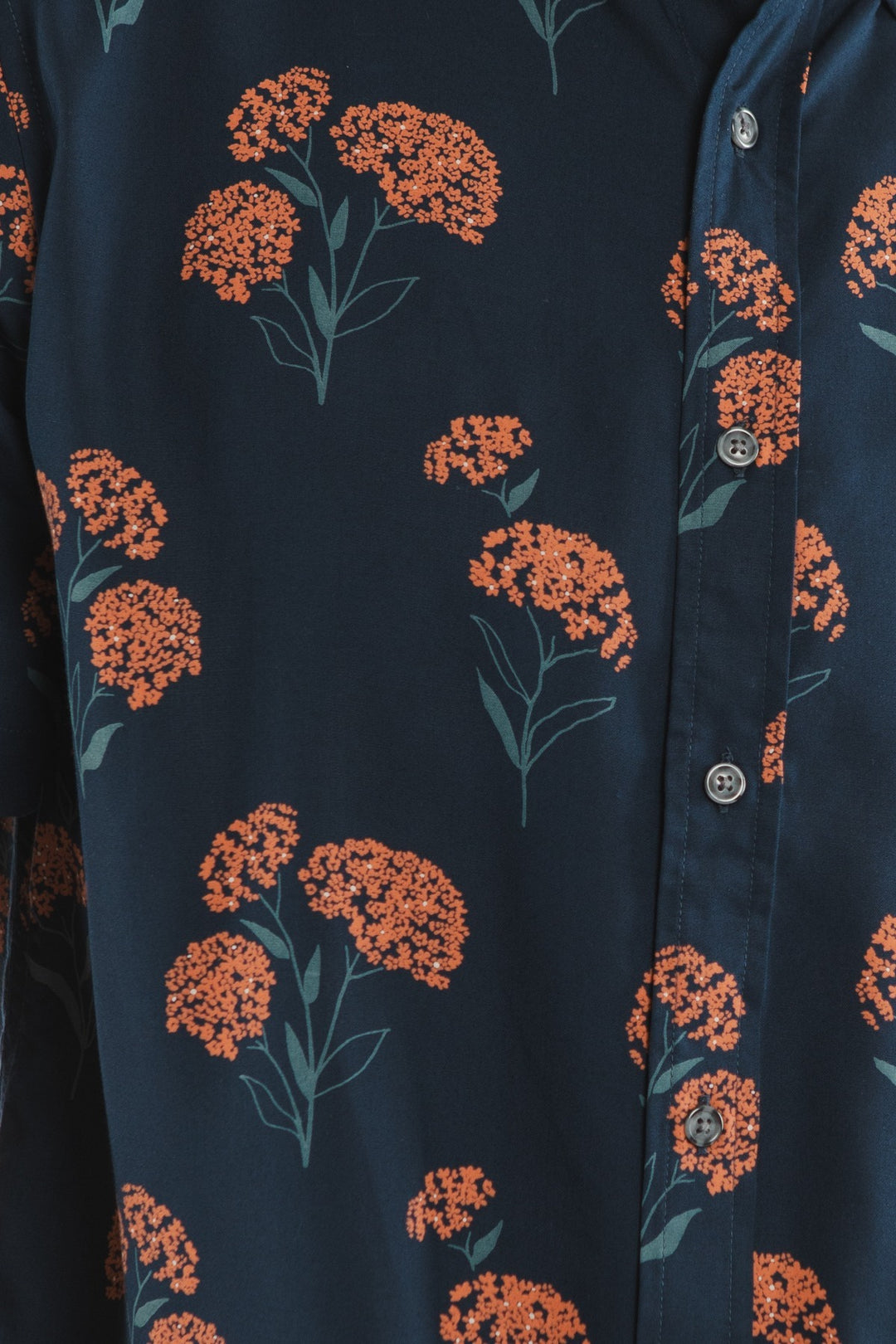 The Grant Slim Shirt / Wildflower by Bridge & Burn is a slim fit modal shirt in navy blue with orange floral patterns, green stems, and buttons down the front—stylish, wrinkle-resistant, and ideal for summer.