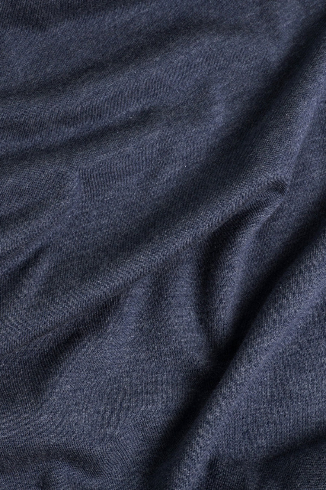 A close-up of the soft, slightly wrinkled navy fabric from the Bridge & Burn Women's Peace In Plants Tee, highlighting its texture and gentle folds.