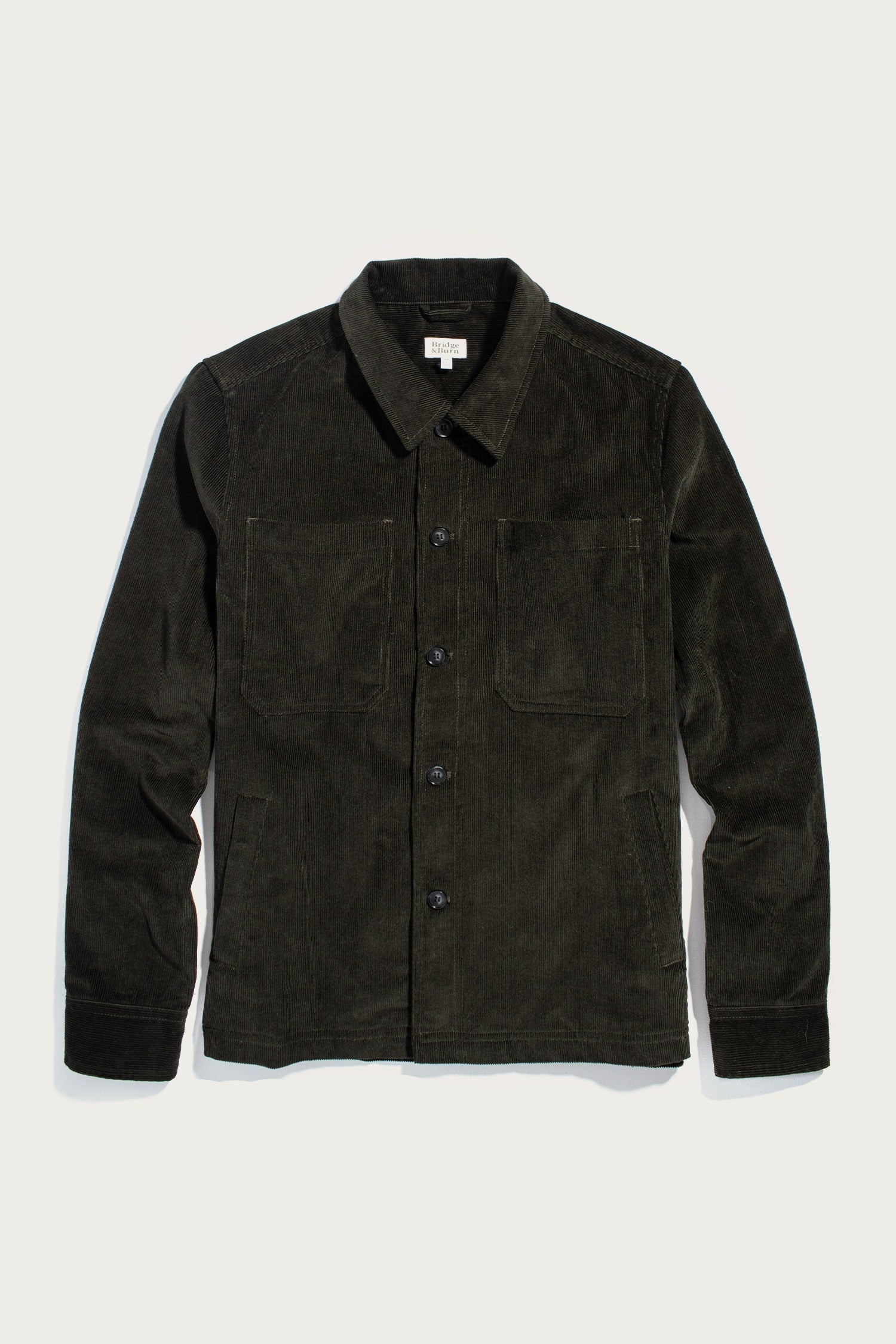 The Bridge & Burn Banks Shirt Jacket in Deep Pine Corduroy features a button-down front, collar, long sleeves, and two chest pockets, displayed flat on a light background.