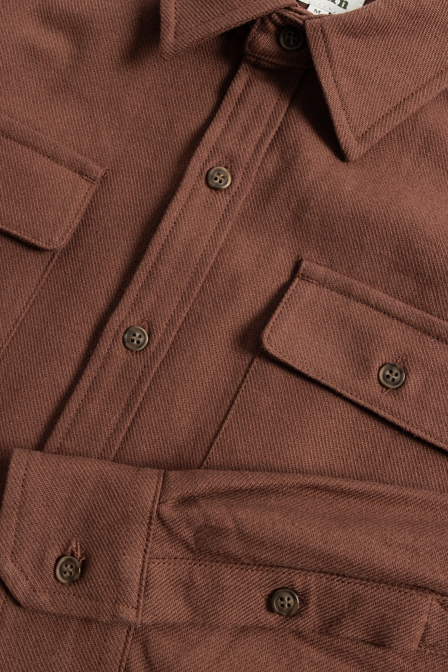 Close-up of the Bridge & Burn Bedford Shirt in Penny Twill, a standard-fit brown cotton shirt with textured fabric, two chest pockets with button flaps, and brown front buttons.