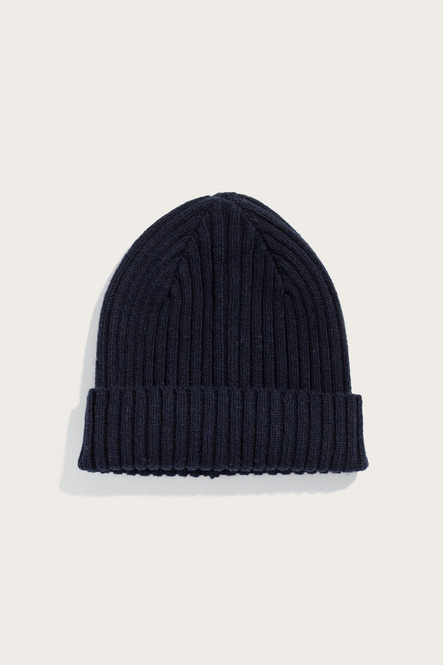 The Bridge & Burn Chunky Ribbed Beanie in Dark Navy, featuring a folded brim, is displayed on a plain light background.