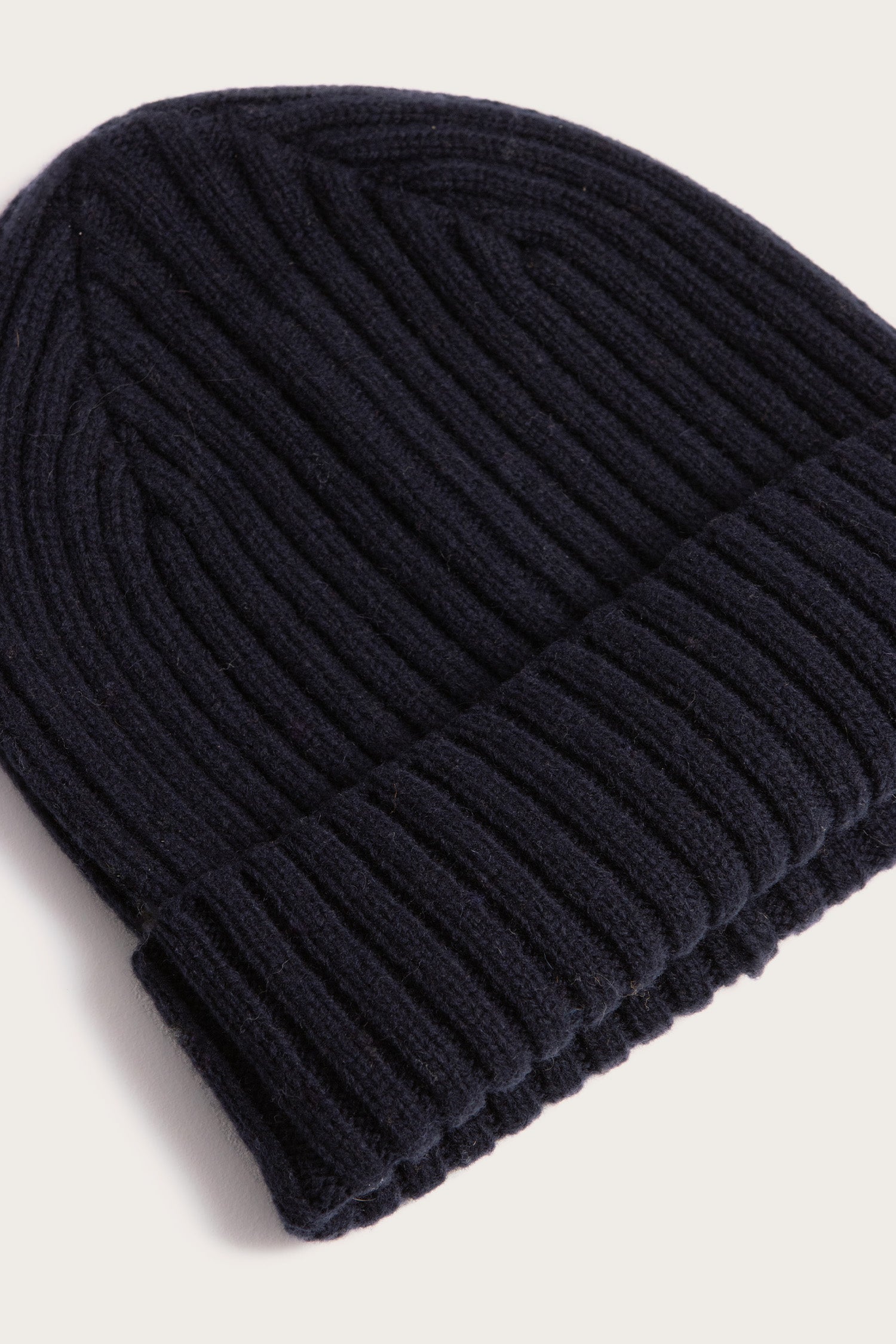 A close-up of the Bridge & Burn Chunky Ribbed Beanie in Dark Navy, featuring a folded brim and soft knit texture, displayed against a light background.