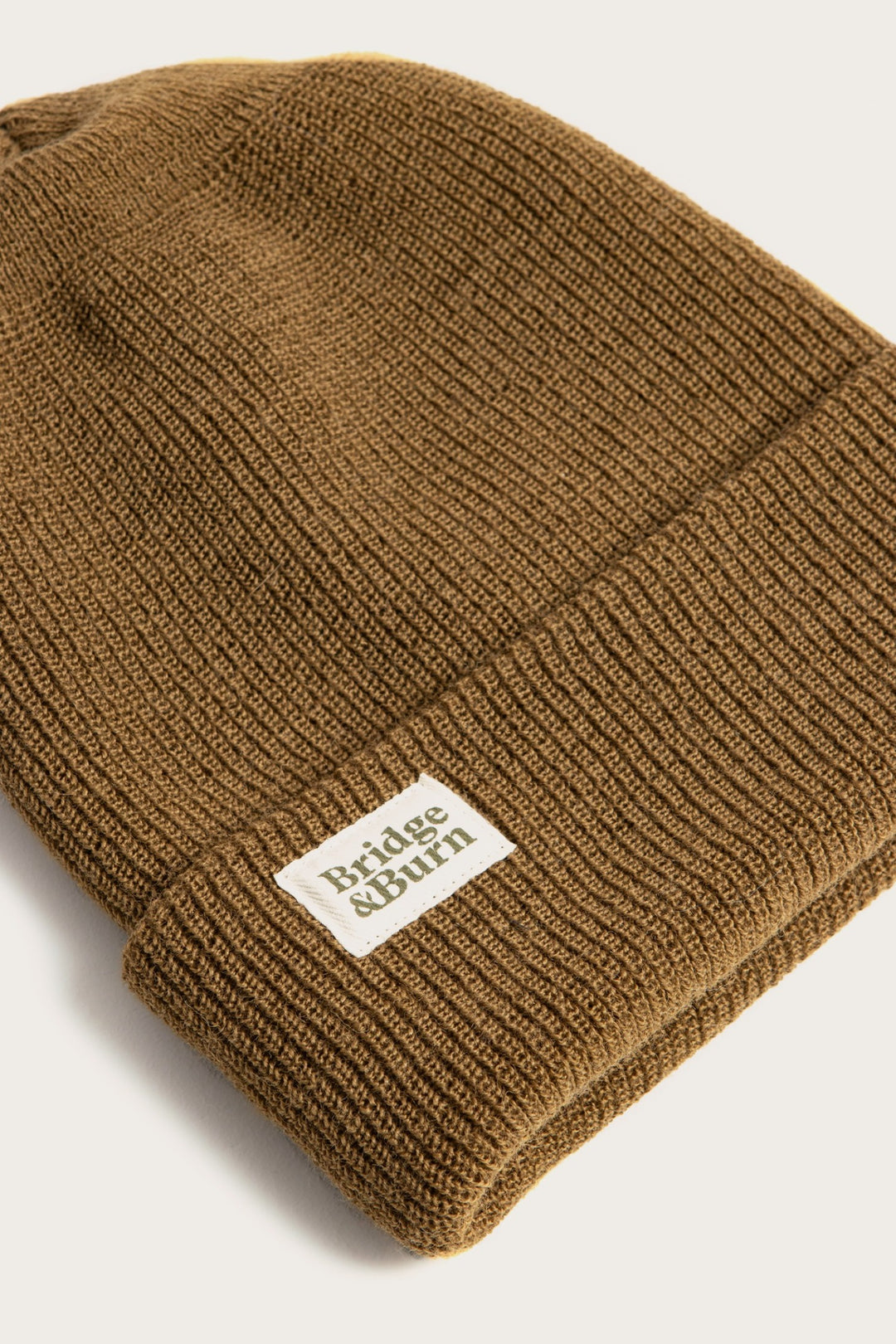 The Bridge & Burn Wool Watch Cap in Coyote is a brown knit beanie with a folded brim and a white rectangular Bridge & Burn label, shown on a light background.