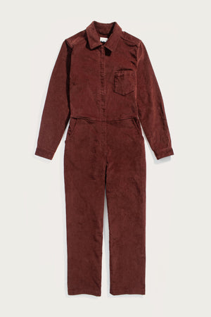 The Bridge & Burn Faye Jumpsuit in Dark Red Pinwale, a women’s corduroy style with long sleeves, collar, chest and side pockets, and workwear-inspired details, is laid flat on a plain white background.