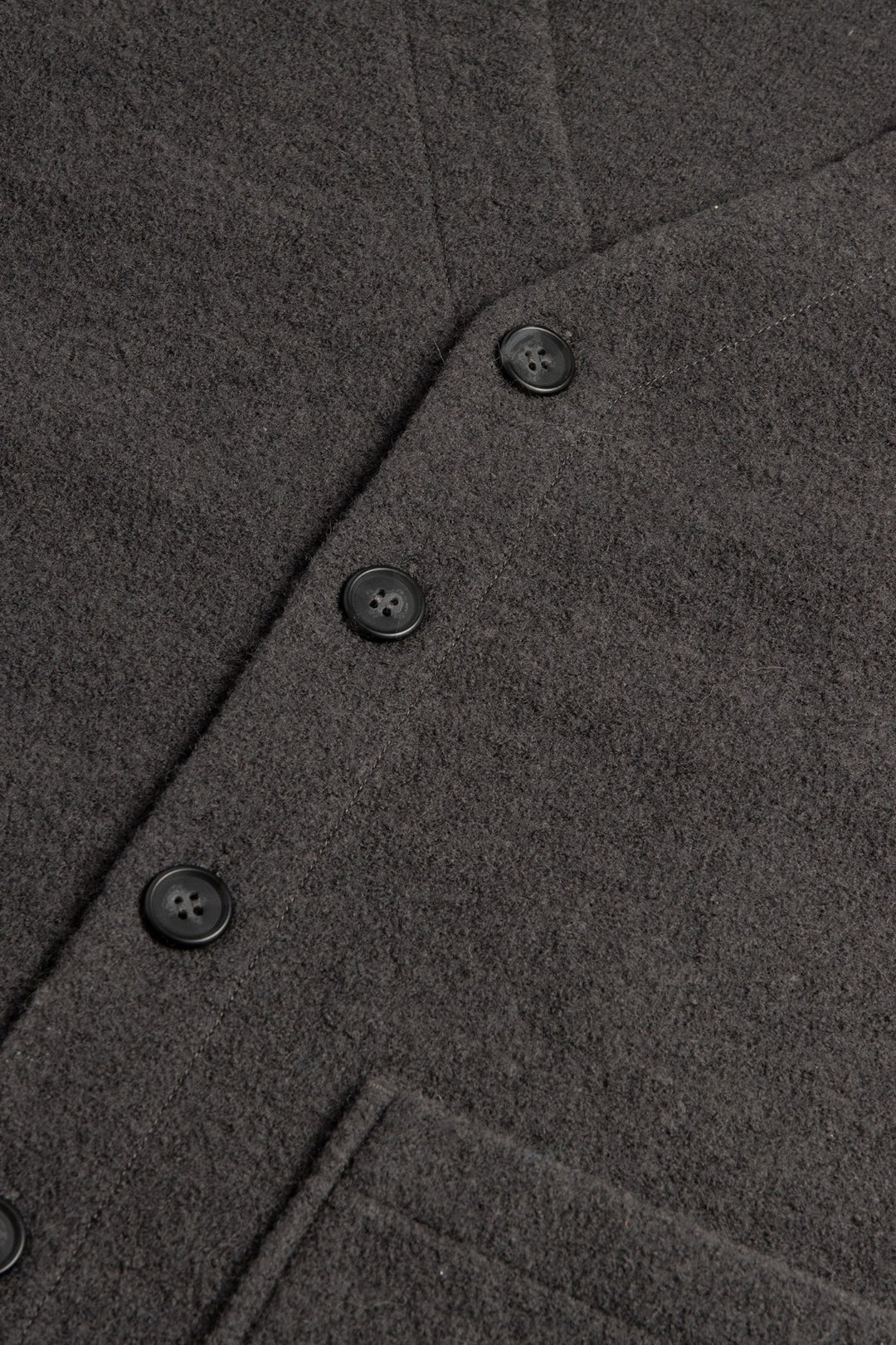 Close-up of the Bridge & Burn Whit Cardigan in Charcoal shows soft, textured boiled wool, four black buttons, and a partial patch pocket near the hem.