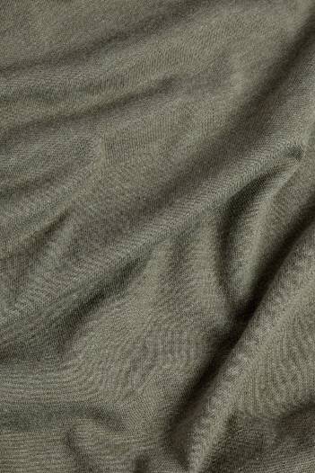 Close-up of olive green fabric with visible texture and natural folds, highlighting the quality of the Bridge & Burn Men's Flown Tee in Olive.