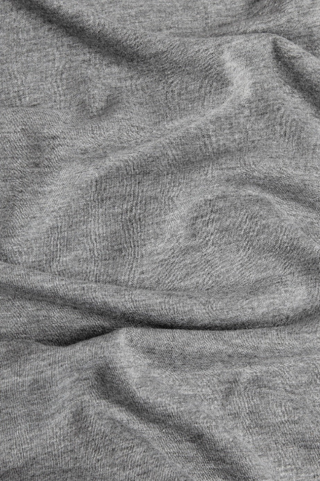 A close-up of the Women's Grown Tee in Grey by Bridge & Burn, showing its textured organic cotton fabric with visible wrinkles and folds.