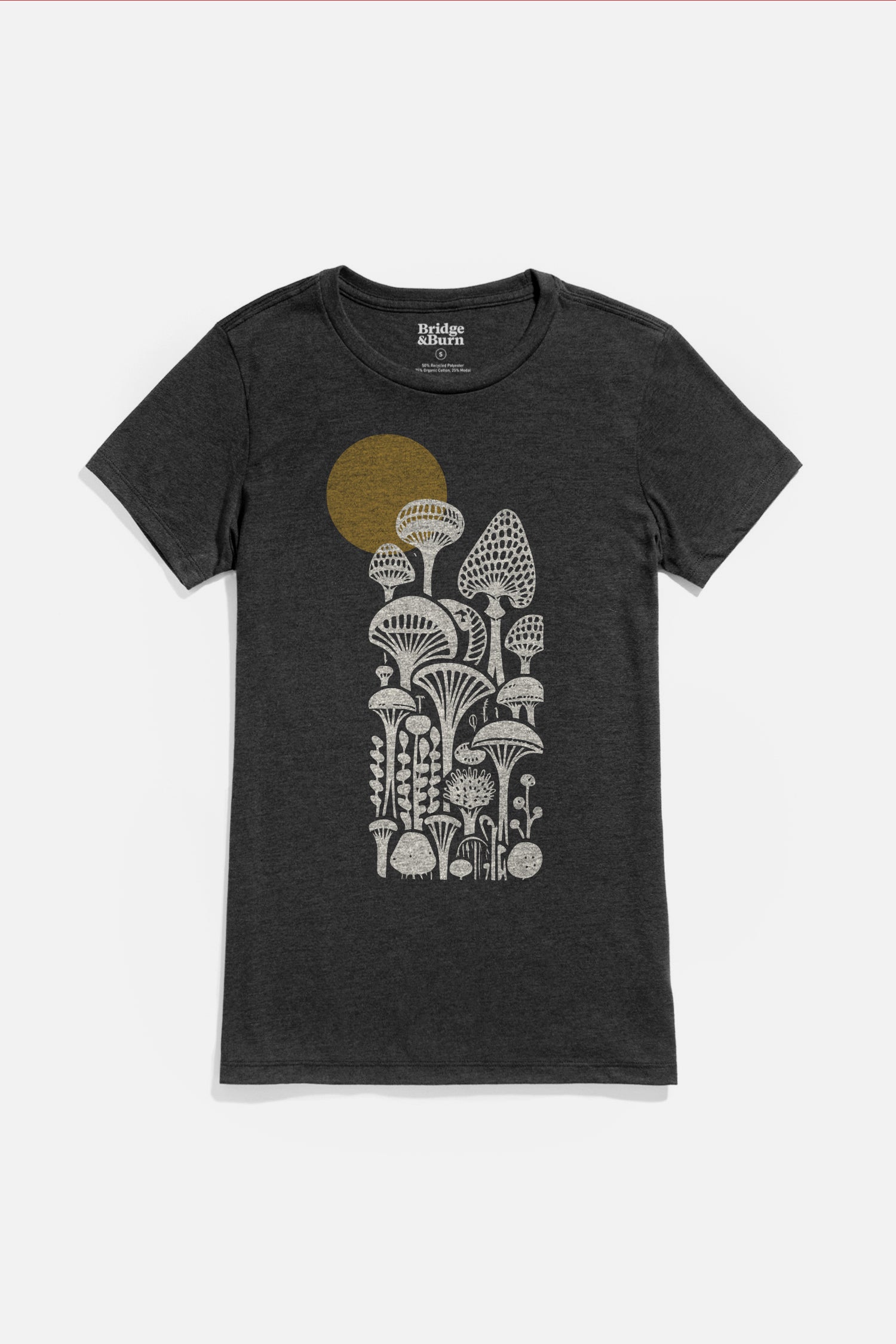 The Bridge & Burn Women's Mycology Tee in black is a lightweight shirt featuring a white graphic of stylized mushrooms and plants with a gold sun-inspired circle in the background.