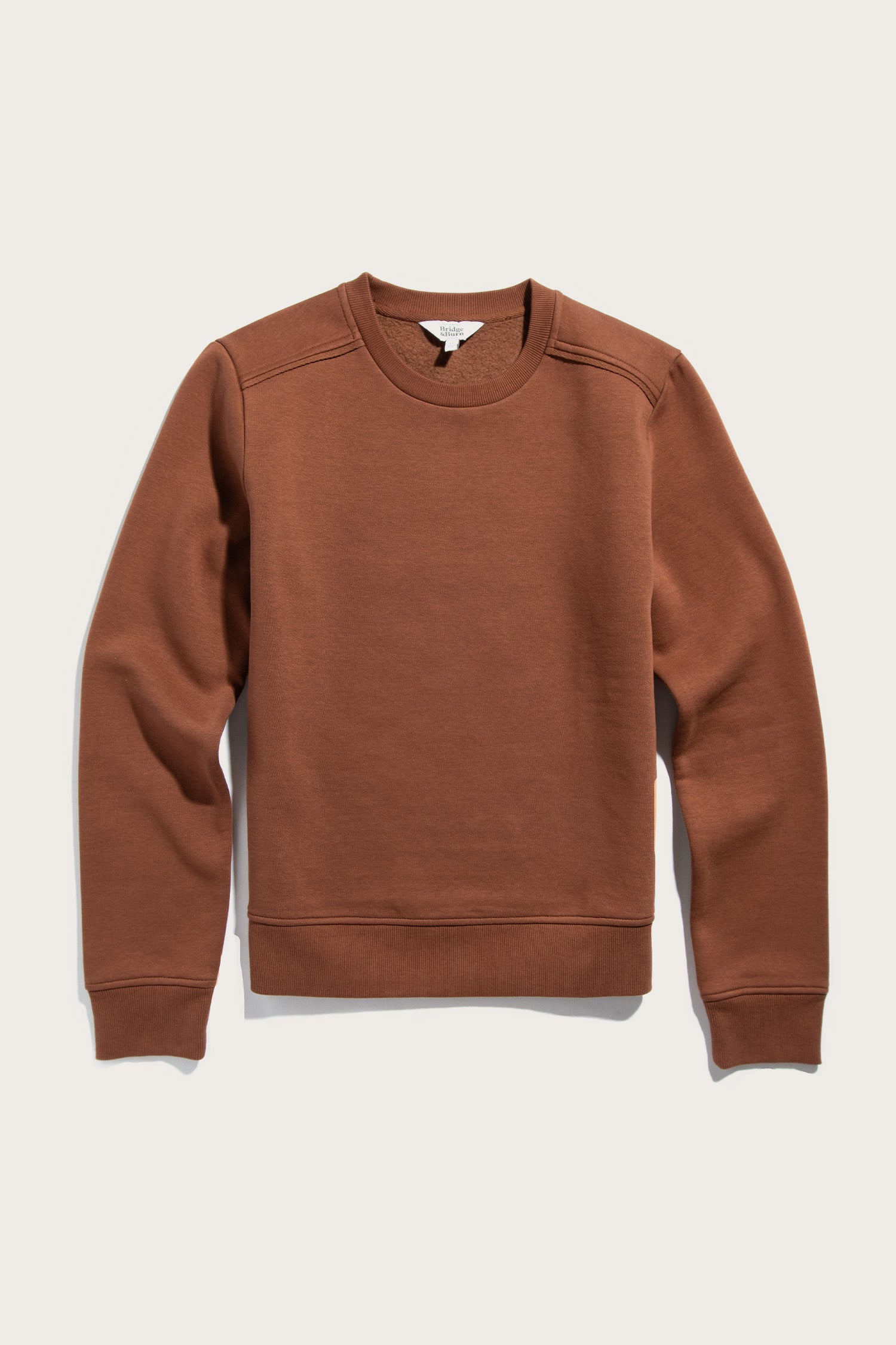The Bailey Crew Sweatshirt in Burnt Umber by Bridge & Burn is a sustainable, soft organic cotton crewneck with long sleeves, ribbed cuffs and waistband, shown flat on a light background.