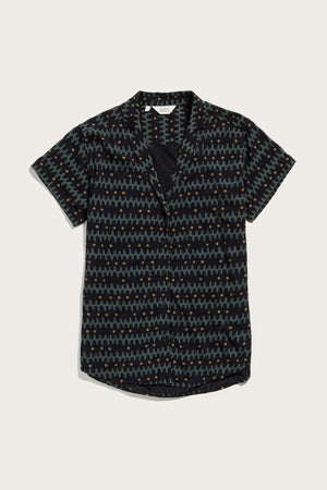 The Bridge & Burn Innes Shirt in Fishbone Ink is a relaxed-fit, short-sleeve button-up featuring a dark base with blue, green, and orange geometric zigzags and dots, finished with a modern lapel collar.