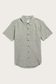 The Bridge & Burn Malcolm Shirt in Sage Chambray is a sustainable men's short-sleeve button-up with a collar and single chest pocket, shown in light gray on a plain white background.