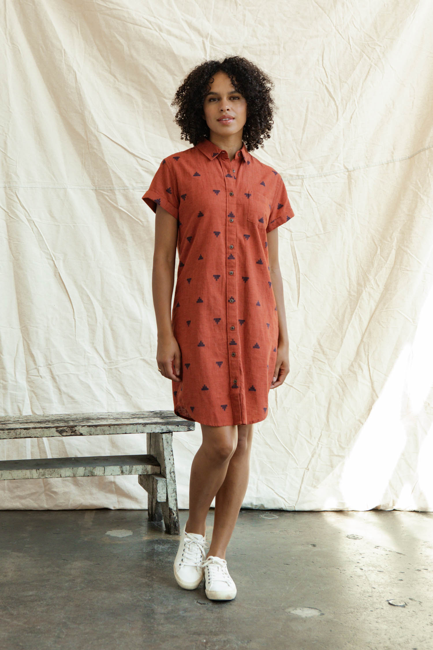 The Loren Shirt Dress by Bridge & Burn features a rust color, short sleeves, button front, collar, chest pocket, and subtle black pyramid fil-coupé details throughout.