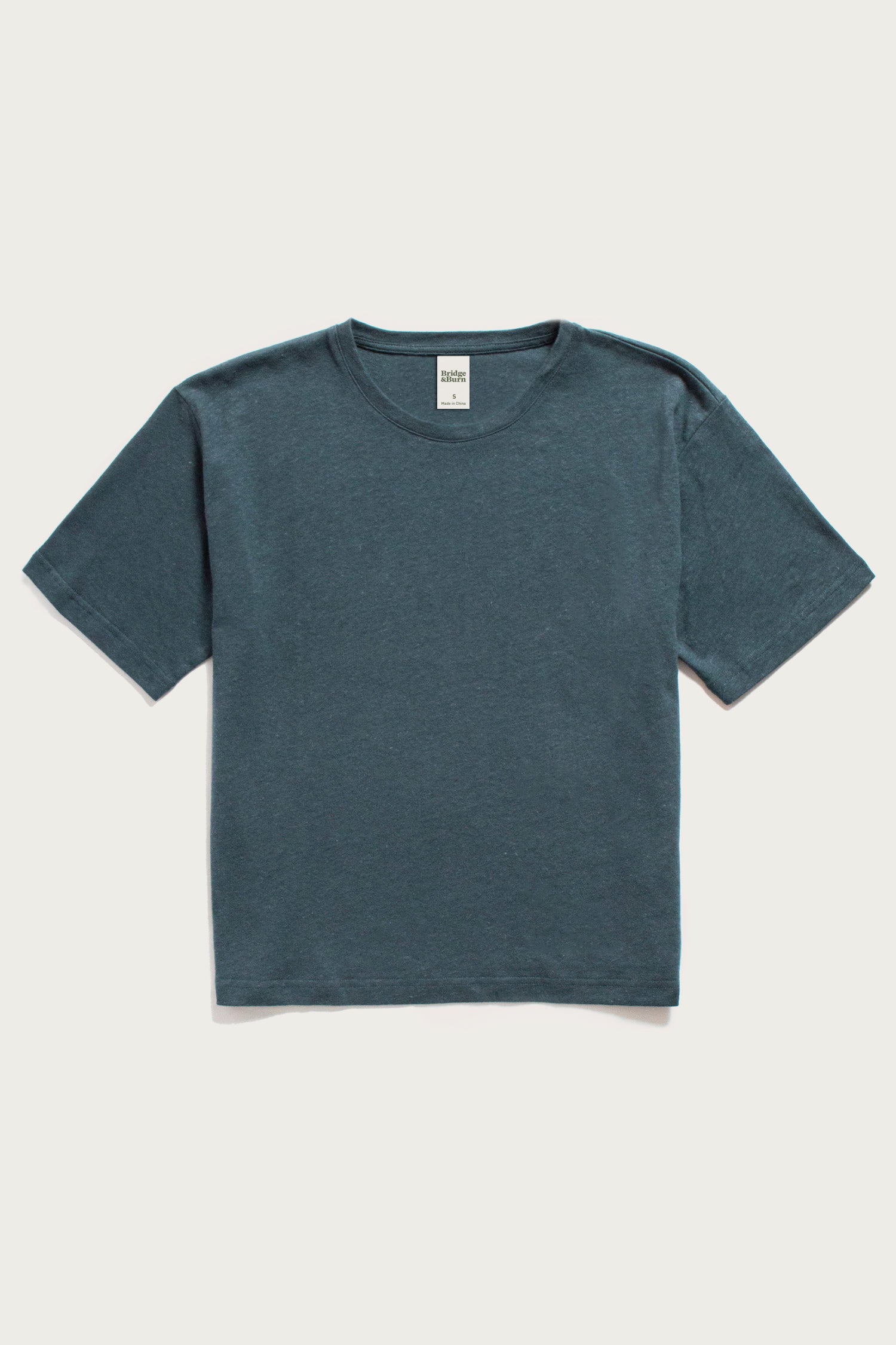 The Bridge & Burn Organic Hemp Boxy Tee in Storm Blue is a soft, vintage-feel, crew neck shirt with short sleeves—crafted from organic cotton hemp and shown laid flat on a white background.