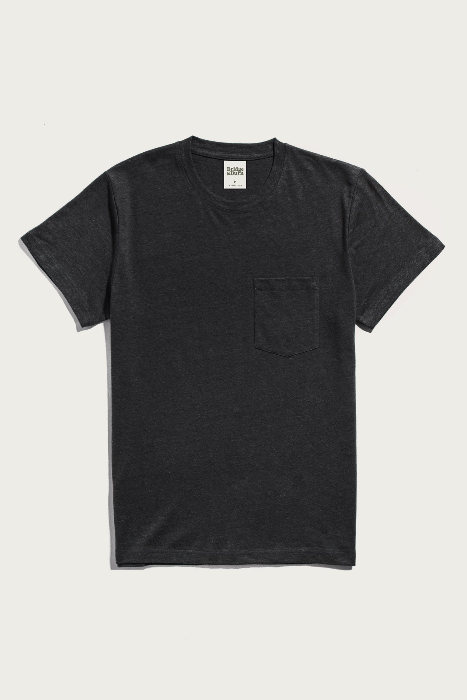 The Bridge & Burn Organic Hemp Pocket Tee in Washed Black is a men's midweight short-sleeve shirt with a chest pocket, shown flat on a white background.