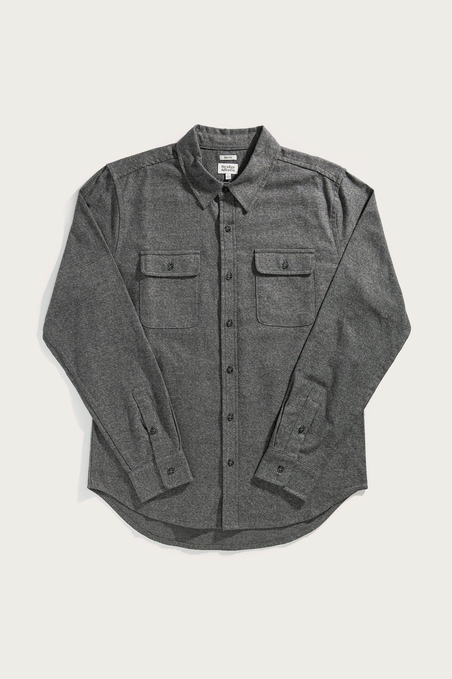 The Bridge & Burn Cole Slim Shirt in Stone is a long-sleeve, button-down slim fit shirt with two button-flap chest pockets, shown laid flat on a white background.