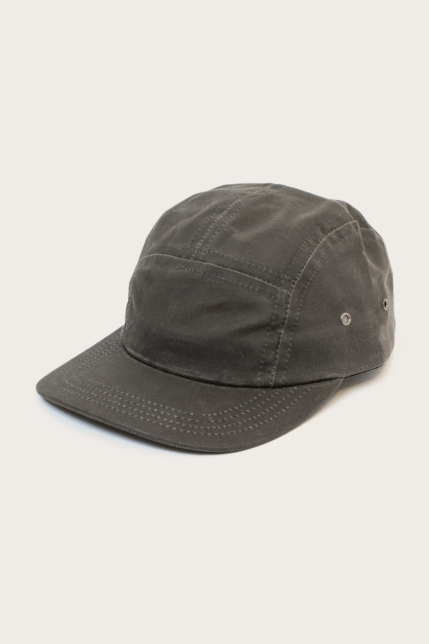 The Bridge & Burn Camper Waxed 5 Panel Cap in Charcoal is a USA-made, dark gray hat featuring five panels, a curved brim, visible stitching, and metal side eyelets, shown on a plain light background.