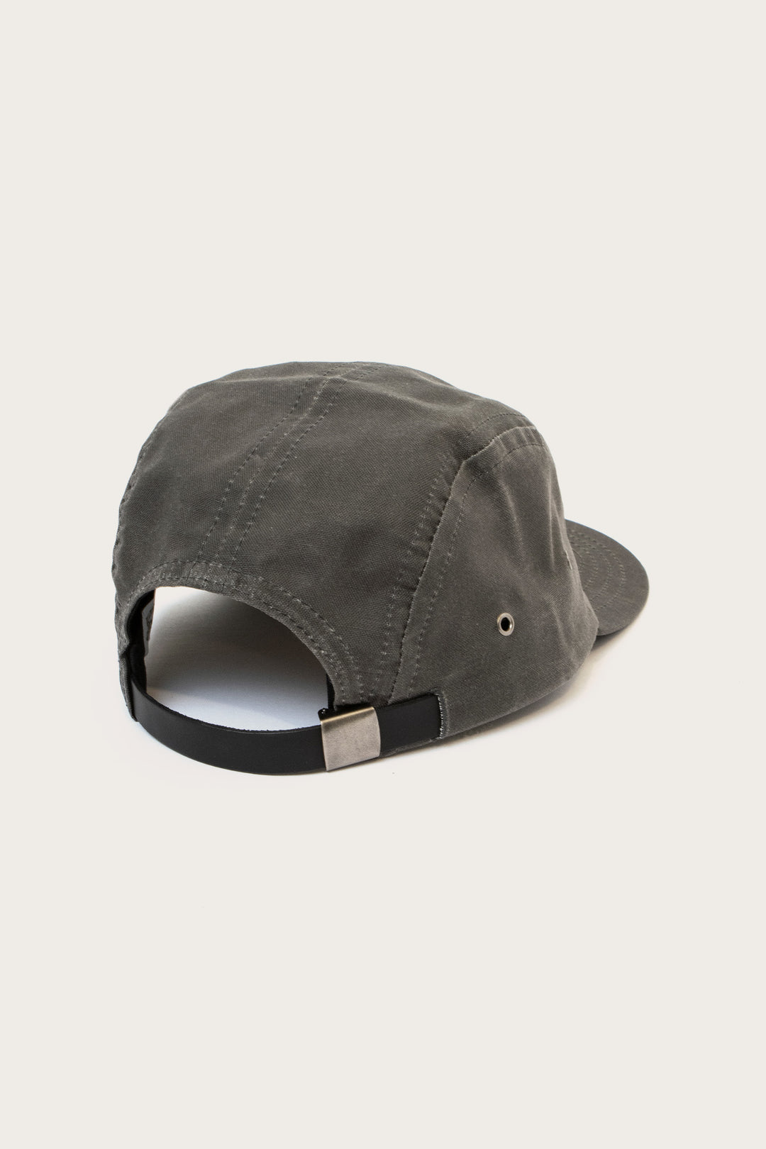 The Bridge & Burn Camper Waxed 5 Panel Cap in Charcoal is shown from the back, displaying its black adjustable strap with a silver buckle and side metal eyelet, all set against a plain white background.