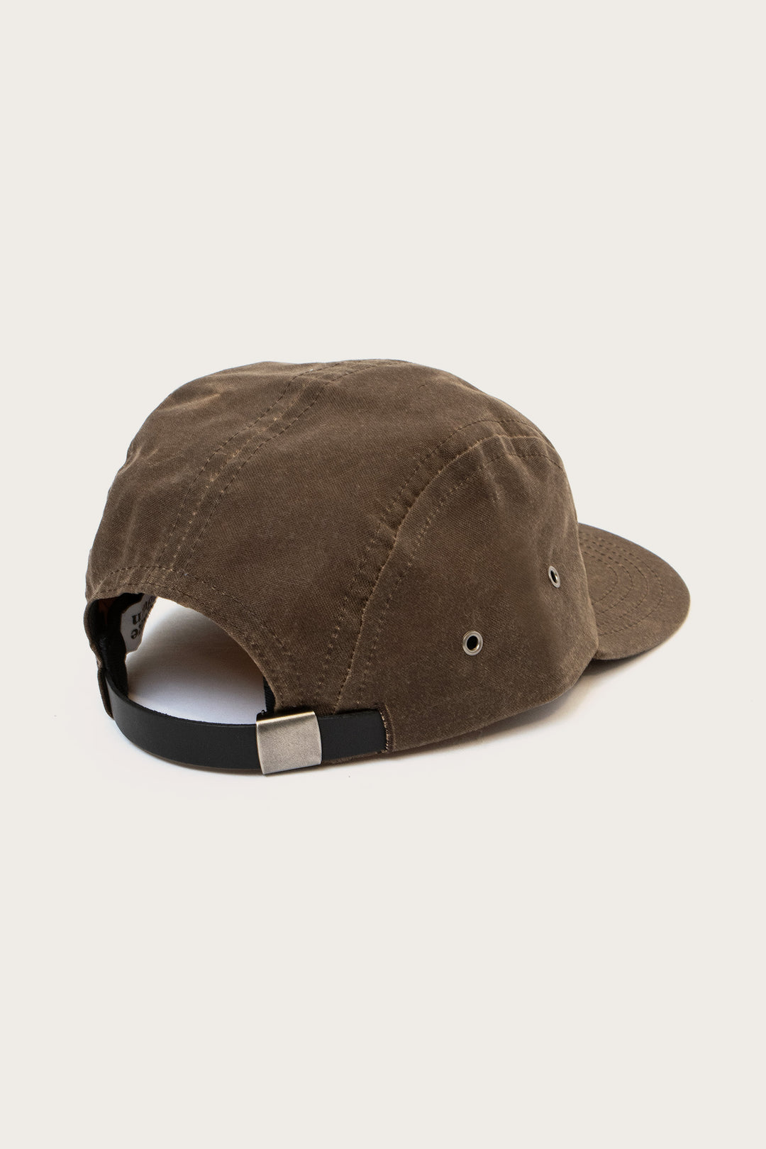 The Bridge & Burn Camper Waxed 5 Panel Cap in Umber is shown from the back with a black adjustable strap, silver buckle, metal side eyelets, and a slightly curved brim against a plain white background.