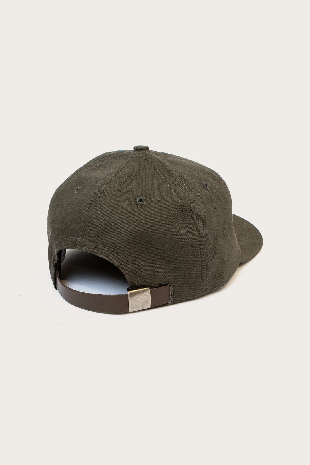 The Bridge & Burn Tree Cap / Olivewood is a dark olive green pinch front hat shown from the back with a brown adjustable strap and metallic clasp, set against a plain light-colored background.