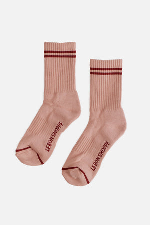 Le Bon Shoppe - Boyfriend Socks in Vintage Pink: light pink socks with two dark red stripes at the top and "LE BON SHOPPE" printed in red on the soles, shown against a plain white background.