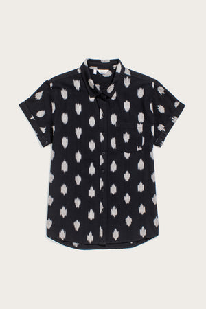 The Bridge & Burn Bea Shirt in Eclipse Ikat features a black background with a white abstract dot pattern, short sleeves, a left chest pocket, and is crafted from 100% cotton. The shirt is shown laid flat on a plain light background.