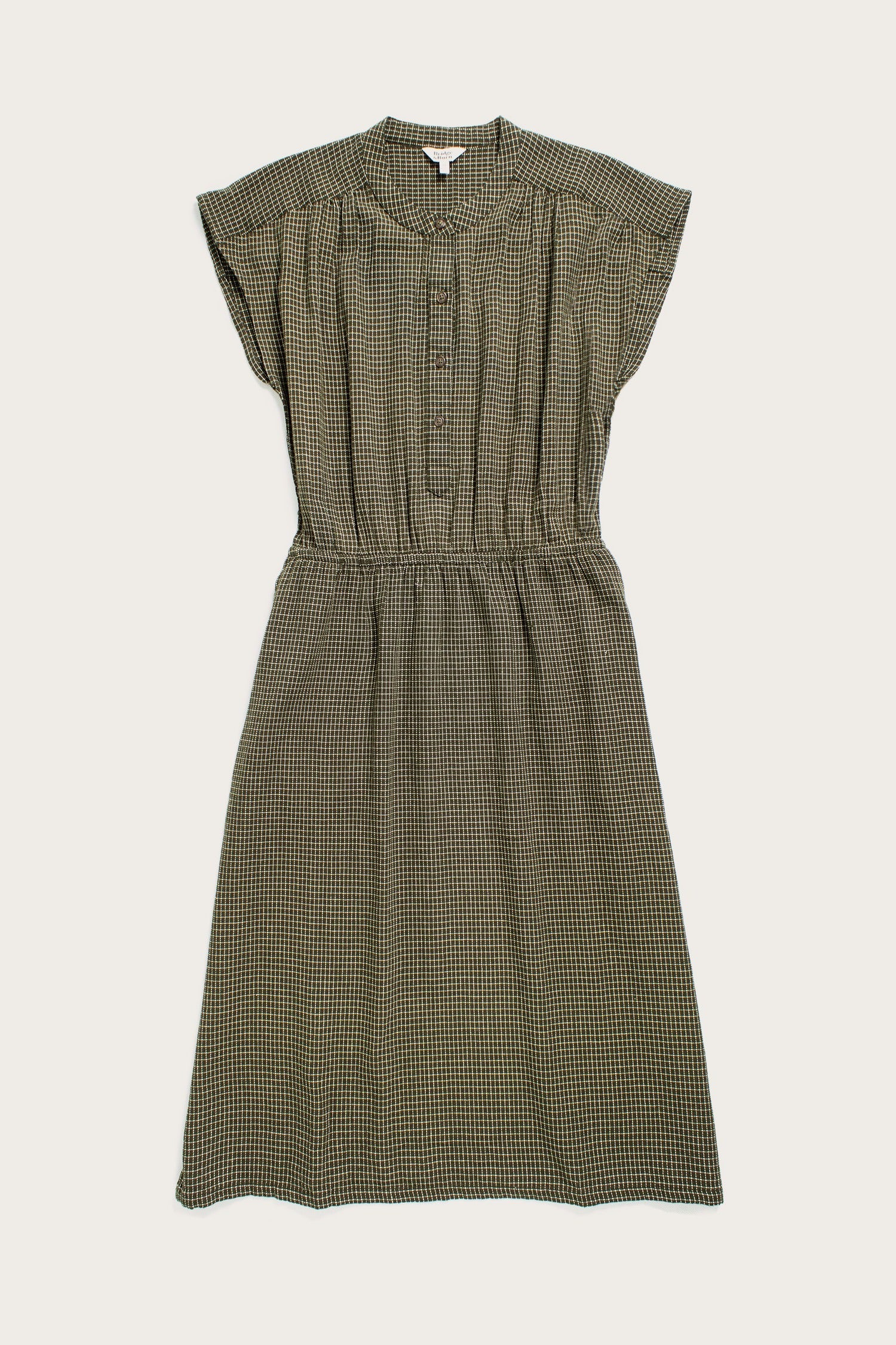 The Lorane Dress by Bridge & Burn in Olive Grid Plaid features a knee-length A-line fit, short sleeves, button front, fitted waist, and relaxed flowy skirt—an ideal casual piece for everyday style.