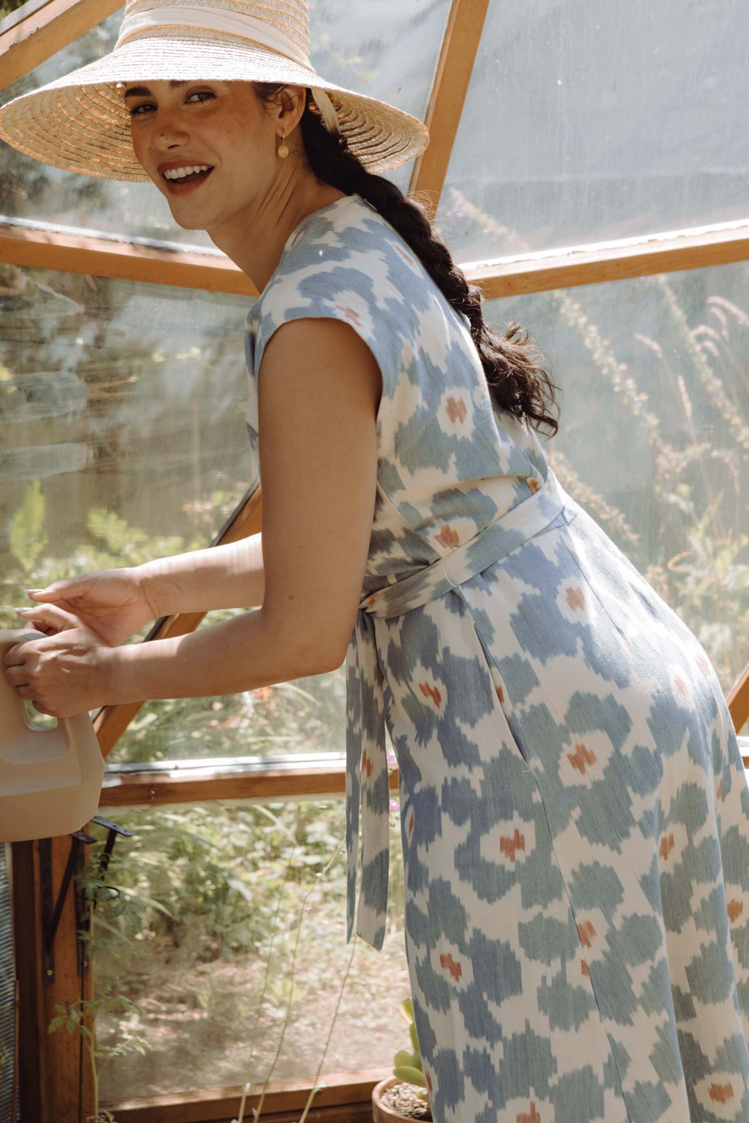 The Eloise Dress / Polar Blossom by Bridge & Burn is a short-sleeve, knee-length A-line dress featuring a blue and white abstract print with orange accents, a round neckline, matching fabric belt, and is shown laid flat on white.
