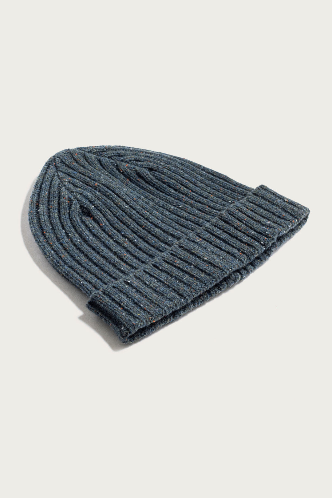 The Bridge & Burn Chunky Ribbed Beanie / Seaside is a cozy, sustainable dark gray knit hat with a folded brim, designed for style and warmth. Shown here lying flat on a white background.