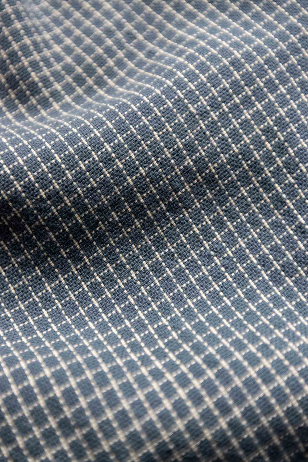 Close-up of the Lorane Dress in Navy Grid by Bridge & Burn, featuring blue cotton fabric with a small white check pattern and soft folds—ideal for a casual A-line look.