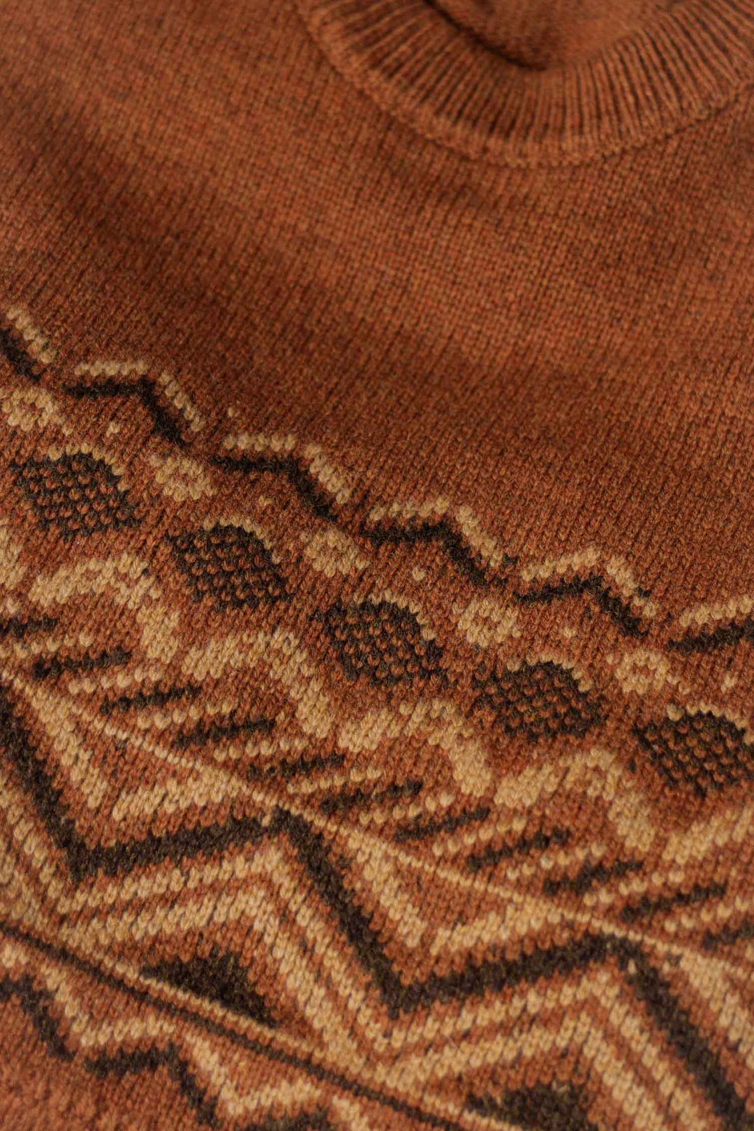Close-up of the Bridge & Burn Rockwood Fairisle Sweater in Walnut Grove, showcasing geometric zigzag and diamond patterns in brown and beige. Textured stitches and a ribbed neckline reflect its RWS certified craftsmanship.