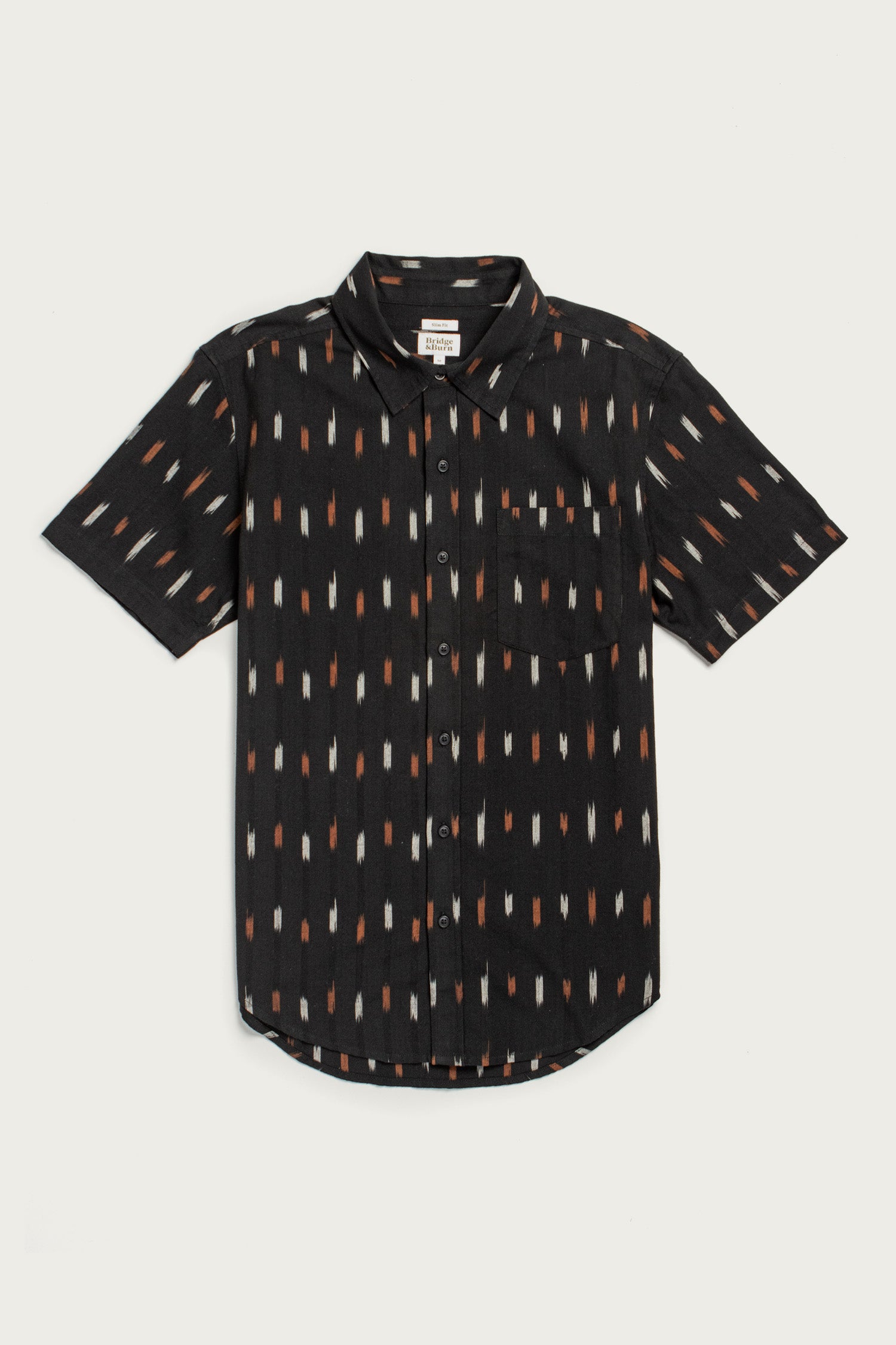 The Harbor Slim Shirt / Dotted Horizon by Bridge & Burn is a lightweight black summer cotton shirt, short-sleeved with a collar, front pocket, and an all-over pattern of vertical orange, tan, and white dashes.
