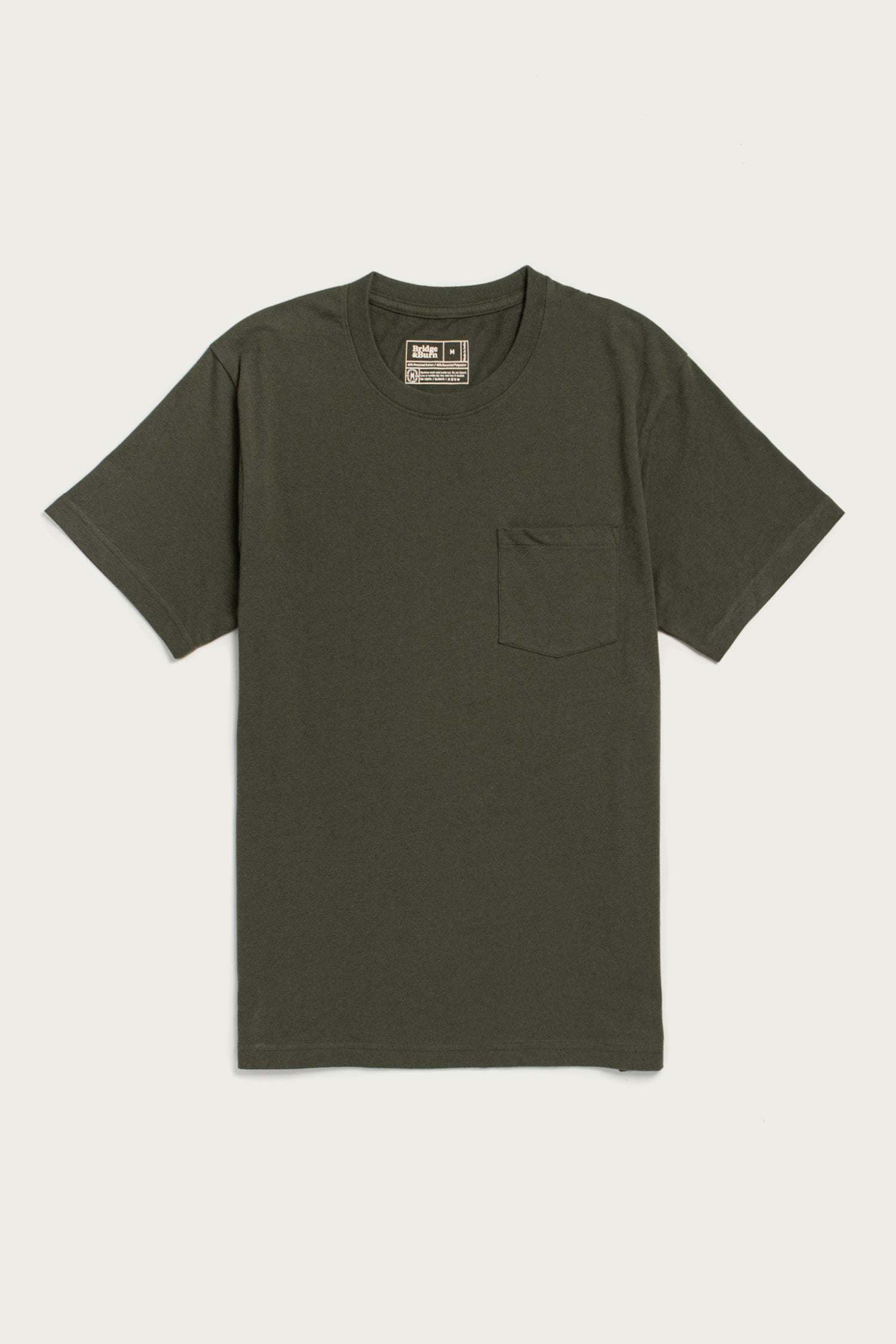 The Bridge & Burn Recycled Pocket Tee in Olive is a sustainable, short-sleeve shirt with a round neckline and a left chest pocket, shown laid flat on a white background.