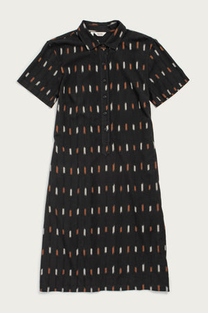The Delia Dress by Bridge & Burn in Dotted Horizon is a short-sleeved, knee-length black organic cotton shirt dress with a collar, buttoned front, and vertical orange, white, and beige rectangle pattern.