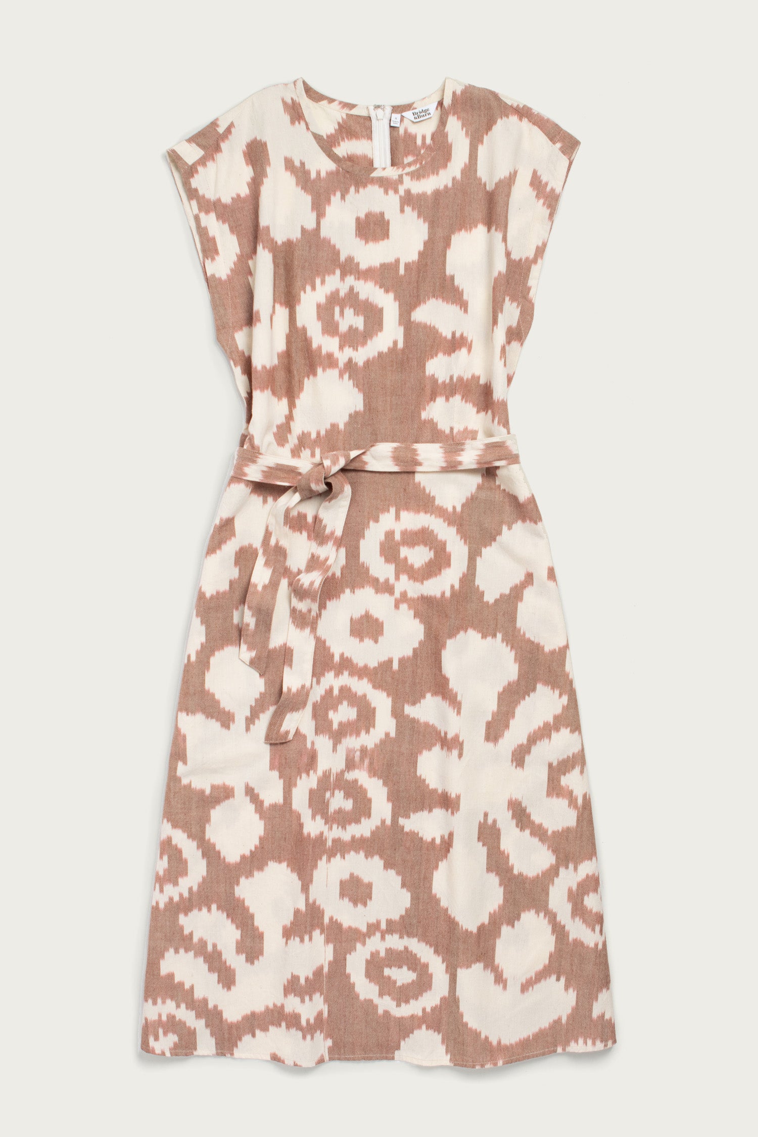 The Eloise Dress in Pop Leaf by Bridge & Burn features a sleeveless A-line cut, round neckline, abstract beige and white print, and a matching fabric belt—an essential piece for any wardrobe.