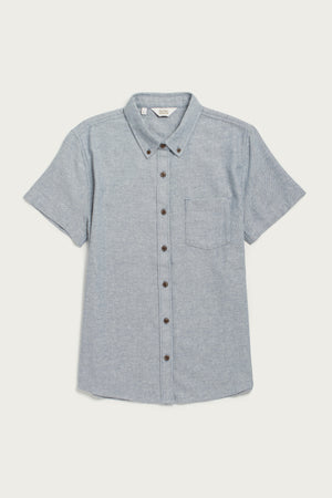 The Bridge & Burn Juniper Shirt in denim twill features short sleeves, a button-down collar, chest pocket, relaxed fit, and is crafted from recycled cotton. Shown here laid flat on a white background.