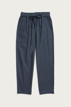 The Bridge & Burn Lark Pant in Dark Slate features a loose fit, elastic waist with drawstring, and a single patch pocket on the left side, shown laid flat against a plain light background.