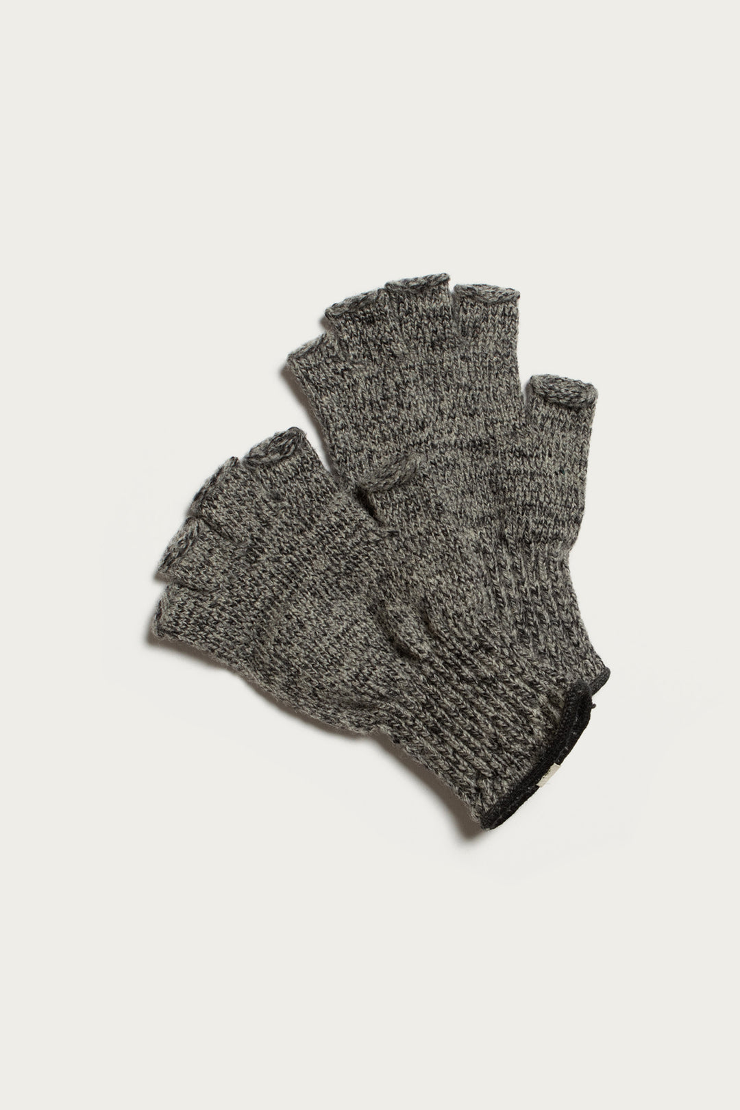 A pair of Bridge & Burn Ragg Wool Fingerless Gloves in Charcoal is laid flat on a white background, highlighting their cozy knit design.