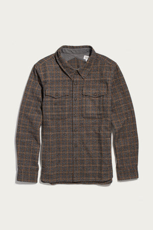 The Bridge & Burn Fielding Shirt Jacket in Hearth Plaid is a workwear-inspired, heavyweight wool-blend flannel featuring a brown and gray plaid, two flap chest pockets, and a collar—shown laid flat on a white background.