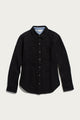 The Dawson Overshirt in Ink Stone by Bridge & Burn is a black button-up shirt jacket crafted from recycled cotton, featuring long sleeves, a collar, two chest pockets, and convenient side pockets. Shown against a plain white background, this modern recycled overshirt is perfect for those who value sustainable clothing.