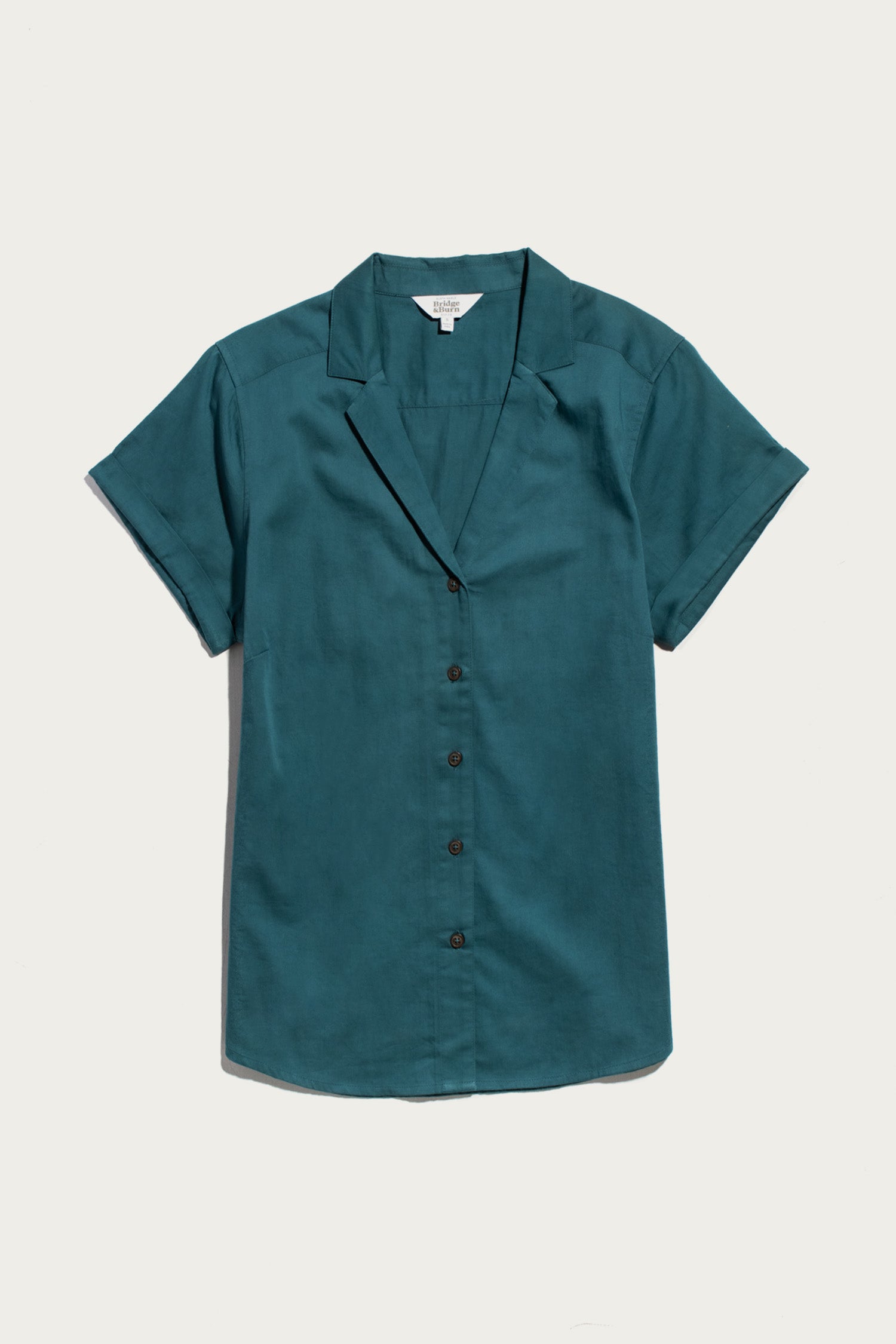 Bridge & Burn Innes Shirt in Deep Sea: a short-sleeve, teal button-up with notched collar and relaxed fit, shown flat on a white background.