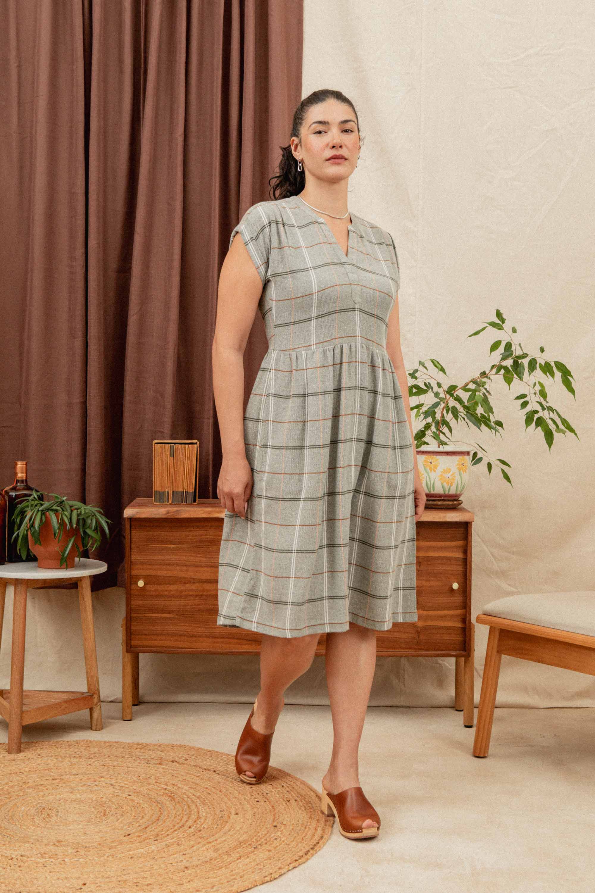 The Ira Dress by Bridge & Burn features short sleeves, knee-length cut, and a pullover style with a wrinkle-resistant olive base and an ember grid plaid. Designed with a v-neckline and gathered waist for easy, polished style.