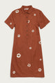The Delia Dress in Redstone Bloom by Bridge & Burn is a short-sleeved, knee-length organic cotton shirt dress with front buttons and scattered white-and-yellow flower prints. It features a straight cut for a simple look.